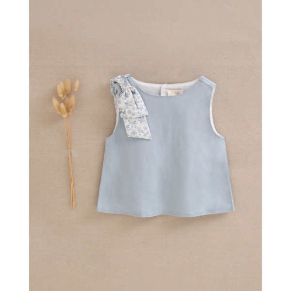 Blusa de niña azul con lazo de flores y abertura trasera
